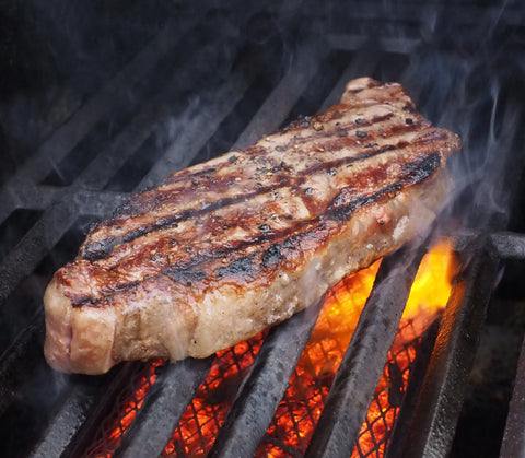 Schwenkersteak über glühenden Kohlen auf dem Grill