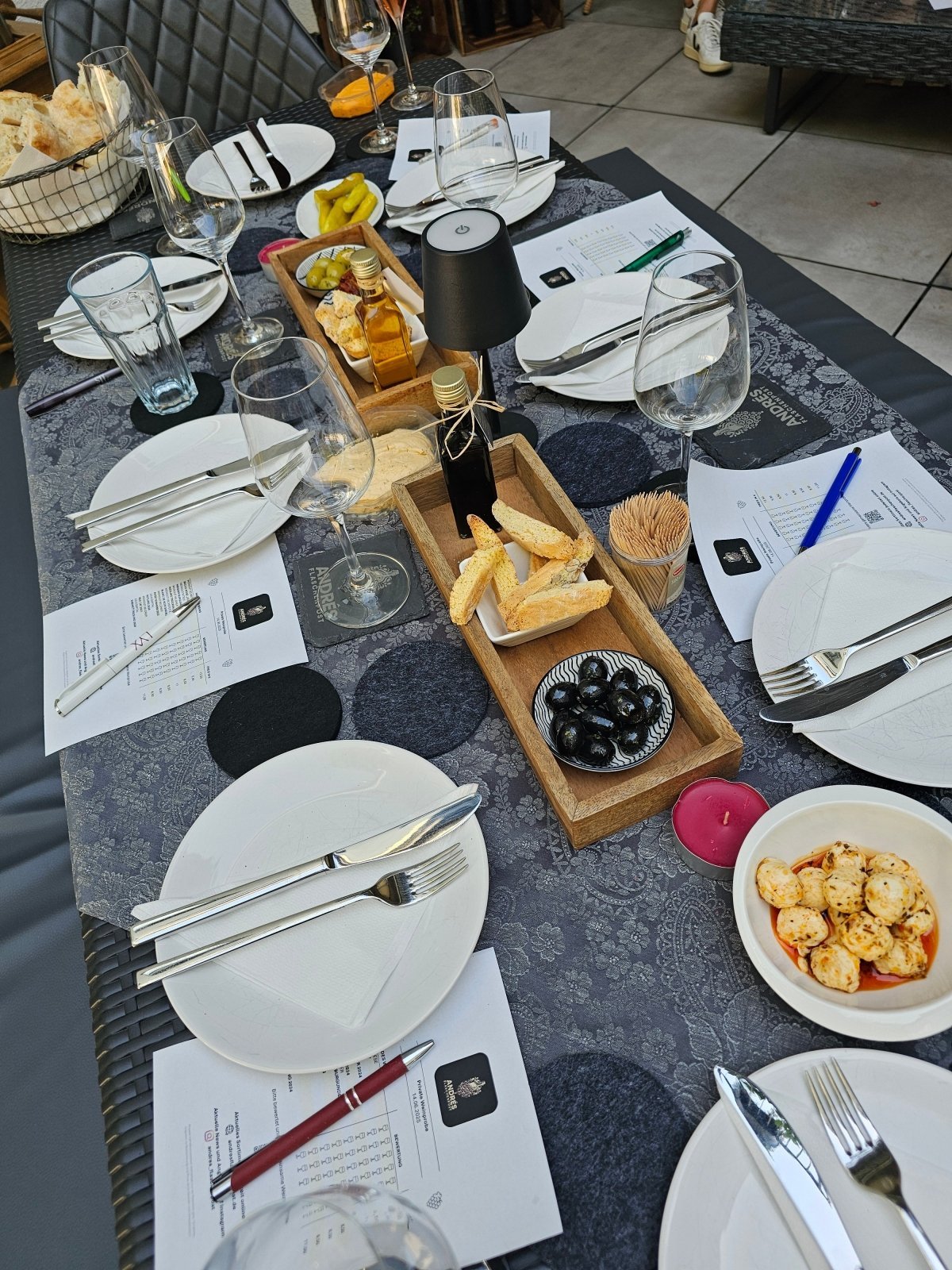 Gedeckter Tisch mit Weingläsern, Snacks und Verkostungsbögen